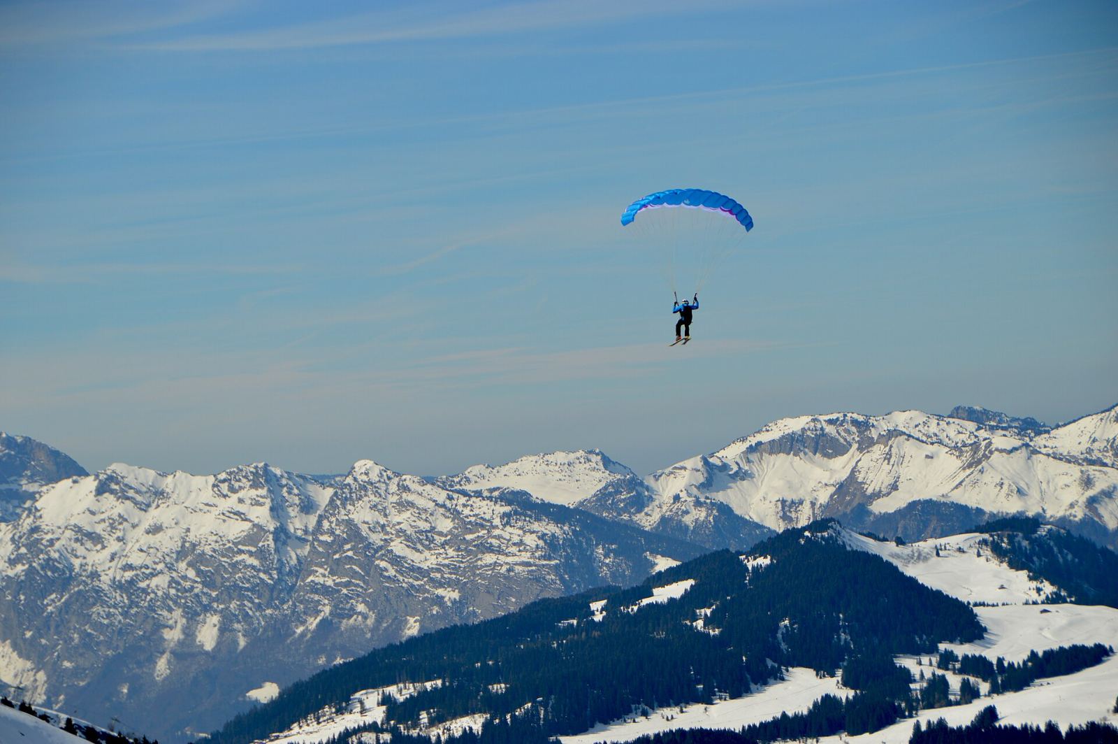 Ein Gleitschirm über den verschneiten Alpen